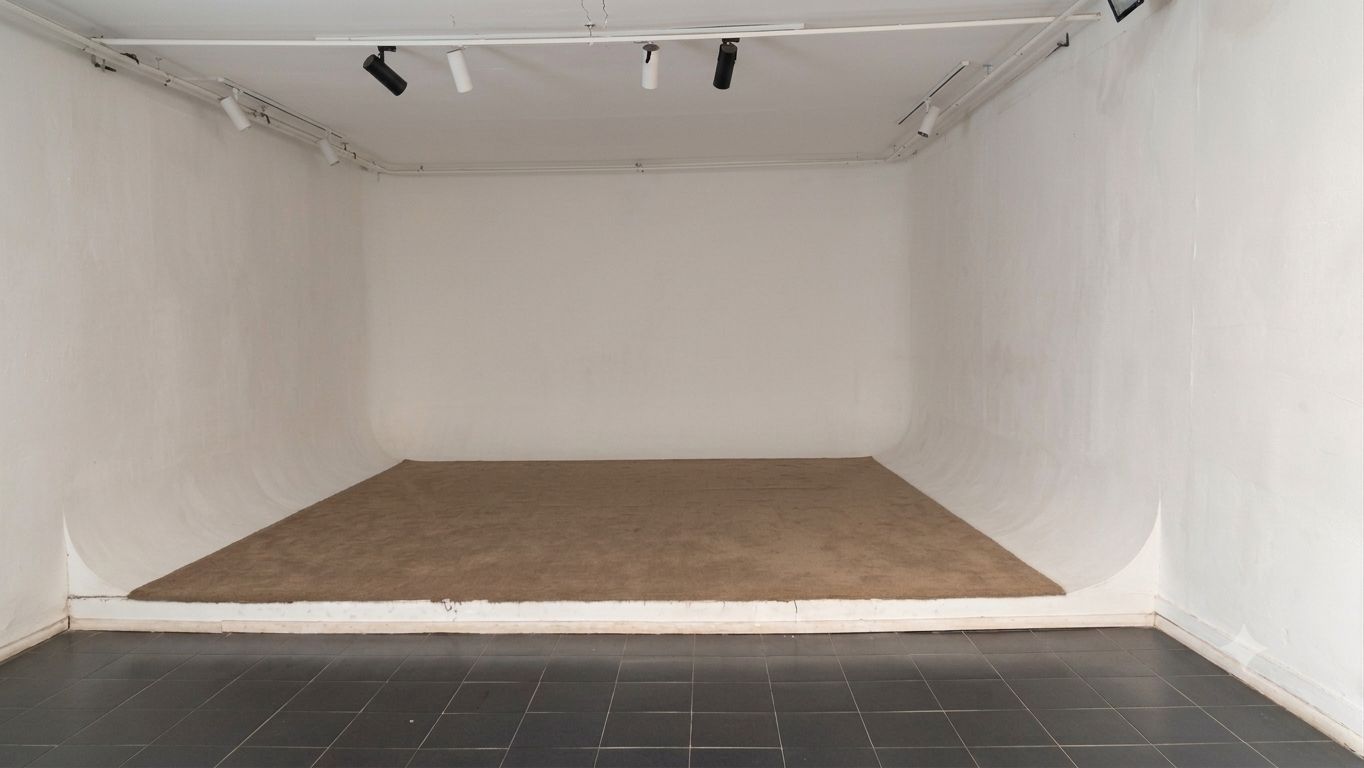 Sinema Siri cinema room — white cyclorama walls, low stage platform and dark tiled floor, Machakos